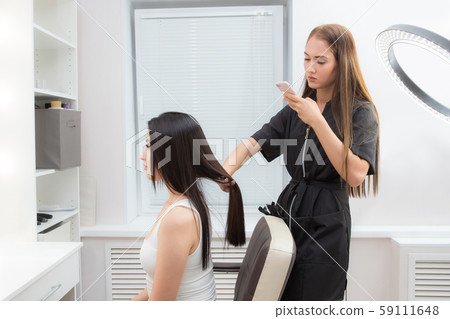 girl stylist hairdresser makes the photo on your phone. Photo of their work for the blog and social 59111648