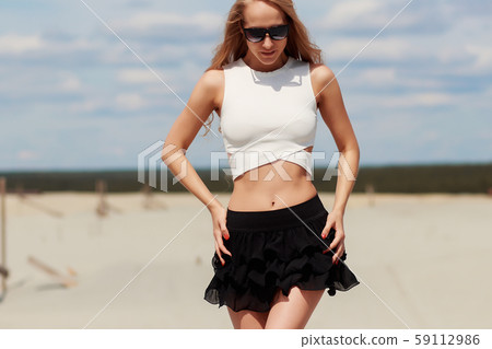 Slim woman stretching raising hands on beach 59112986