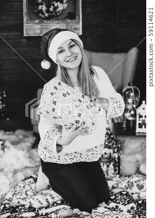 Happy woman in santa hat holding present box. 59114621