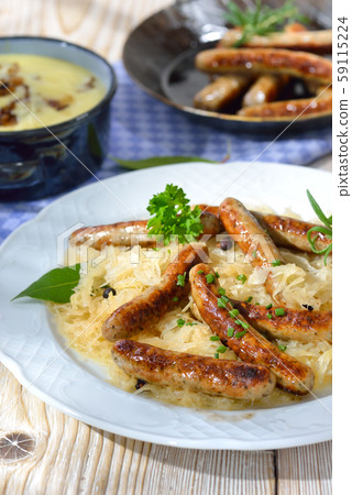 Fried Bavarian sausages from Nuremberg served on sauerkraut, mashed potatoes 59115224