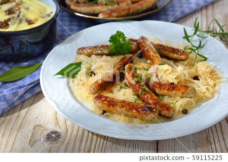 Fried Bavarian sausages from Nuremberg served on sauerkraut, mashed potatoes 59115225