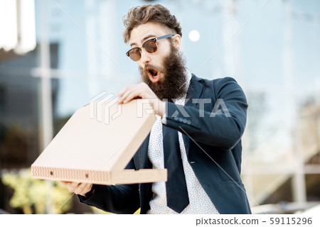 Businessman with pizza outdoors 59115296