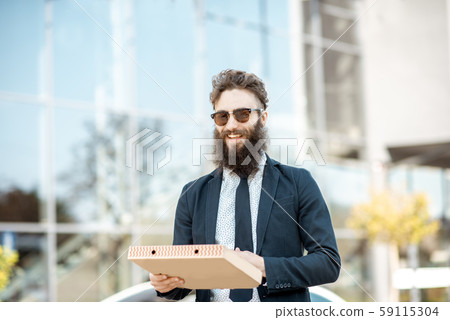 Businessman with pizza outdoors 59115304