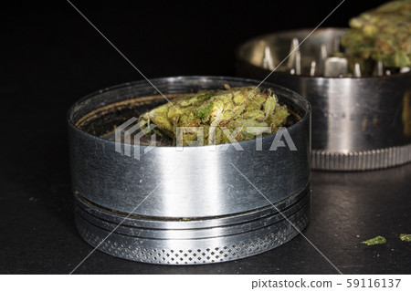 Metal grinder with marijuana, isolated on a black Metal grinder with marijuana, isolated on a black 59116137
