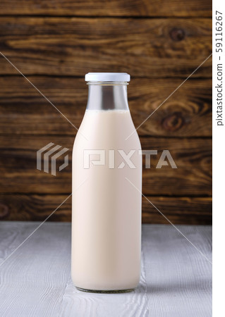 Bottle of soy milk on white table over dark wooden 59116267