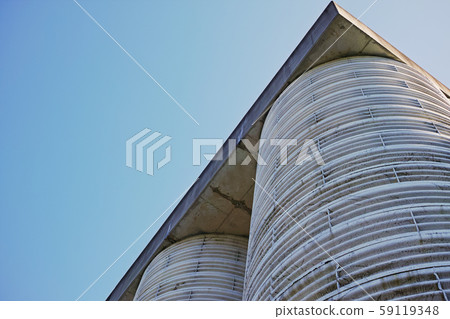Giant retaining wall and blue sky lined with cylinders 59119348
