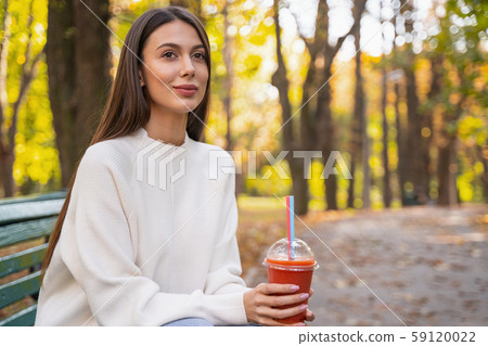 Pretty woman sitting in the park alone 59120022