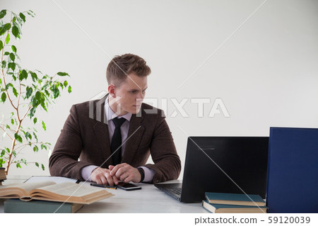 a man in a business suit works at a computer in the office a man in a business suit works at a computer in the office 59120039