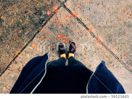woman feet in black clothes stand with orange petals fall in raining day woman feet in black clothes stand with orange petals fall in raining day 59121683