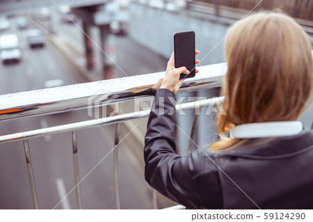 Woman photographing the road with a cellphone 59124290
