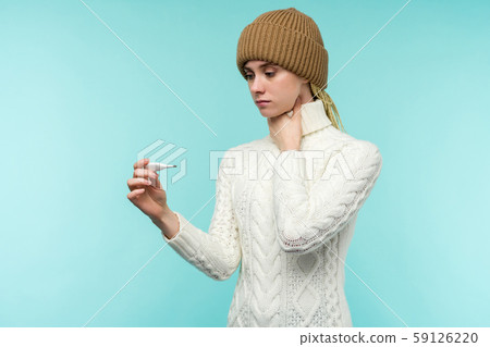 Young woman having flue taking thermometer against Young woman having flue taking thermometer against 59126220