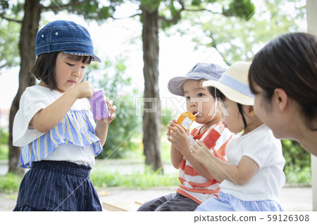 Children drinking juice in the park 59126308