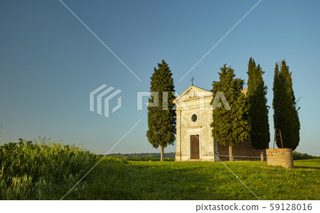 Little chapel surrounded by cypress trees. 59128016