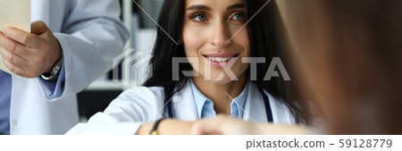 Beautiful smiling female GP shaking hands with visitor 59128779
