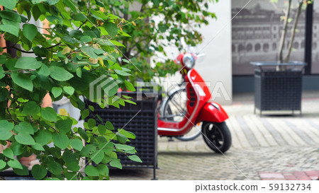 Red scooter parked in the yard 59132734