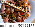 Cooked tasty dish fried shrimp with vegetables in sweet and sour sauce. Carrots, broccoli, cauliflower, shrimp are on a white plate. 59133485