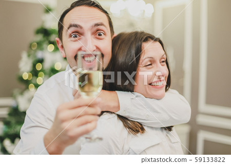 Making fool and entertainment concept. Photo of couple celebrating new year with champange. Childish Making fool and entertainment concept. Photo of couple celebrating new year with champange. Childish 59133822