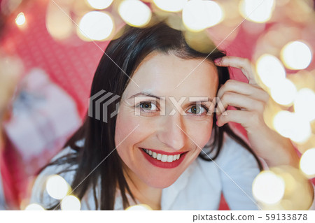 Closeup photo of lovely woman in celebrating atmosphere, looking at the camera, smiling. 59133878
