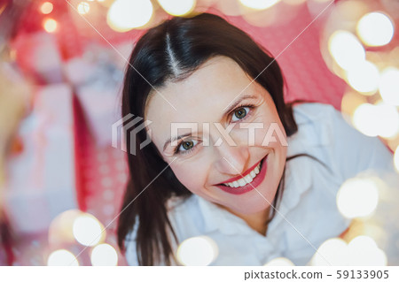 Closeup photo of lovely woman in celebrating atmosphere, looking at the camera, smiling. 59133905