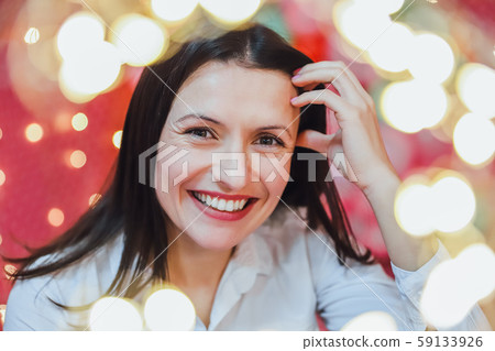 Closeup photo of lovely woman in celebrating atmosphere, looking at the camera, smiling. 59133926