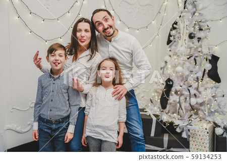 Funny photo of funky positive mom, dad and siblings posing, showing tongues and making grimaces on 59134253