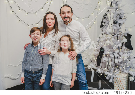 Funny photo of funky positive mom, dad and siblings posing, showing tongues and making grimaces on Funny photo of funky positive mom, dad and siblings posing, showing tongues and making grimaces on 59134256