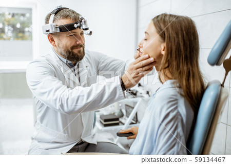 Otolaryngologist with patient in ENT office 59134467