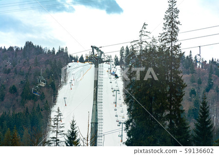 Ski slope with lift on the background of evergreen 59136602