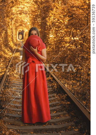 Beautiful woman in red autumn dress walks the Beautiful woman in red autumn dress walks the 59136739