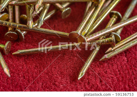 Texture of yellow nails on red background. 59136753