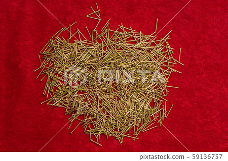 Pile of little nails on red background. Pile of little nails on red background. 59136757