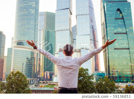 Back view of businessman looking on copy space while standing against glass skyscraper Back view of businessman looking on copy space while standing against glass skyscraper 59136851