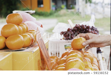 Young woman choosing orange at supermarket. Young woman choosing orange at supermarket. 59138152