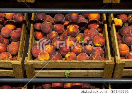 Wooden lug box with soft and mellow peaches on counter 59141991