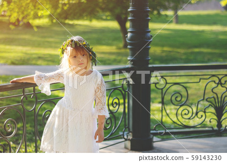 Beautiful little girl with flower wreath on her 59143230
