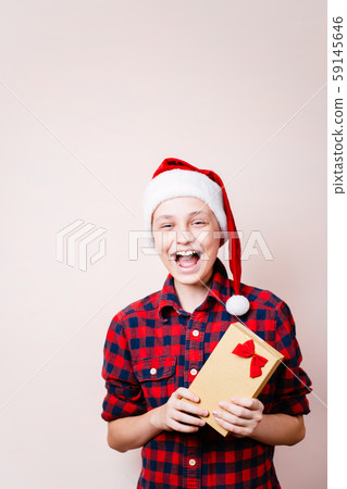 Excited boy in santa claus hat with present box Excited boy in santa claus hat with present box 59145646