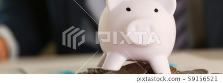 Hand businessman putting pin money into pig Hand businessman putting pin money into pig 59156521