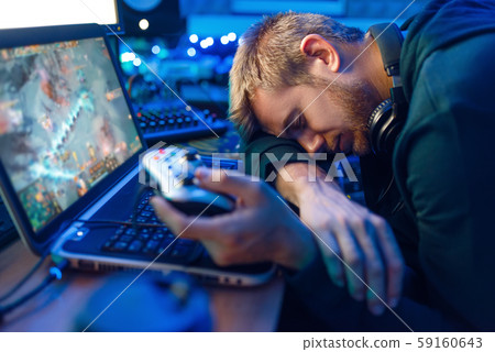 Male gamer sleeping at his laptop after challenge Male gamer sleeping at his laptop after challenge 59160643