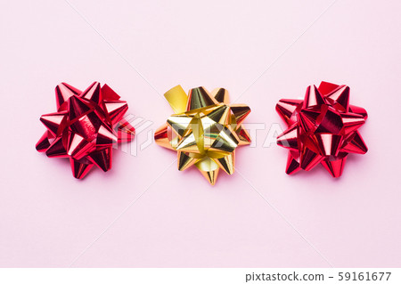 Gold and red Christmas bows on pink background. Gift concept greetings for holidays birthday Wedding New year Christmas mother's Day. Copy space. 59161677
