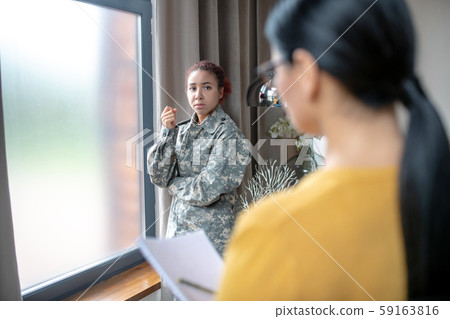 Stresse young servicewoman talking to her psychologist Stresse young servicewoman talking to her psychologist 59163816