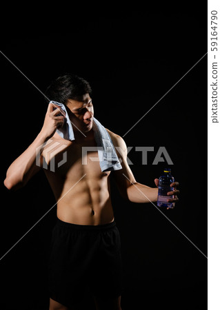 athletic muscular bodybuilder man with naked torso six pack abs holding water. fitness workout concept athletic muscular bodybuilder man with naked torso six pack abs holding water. fitness workout concept 59164790