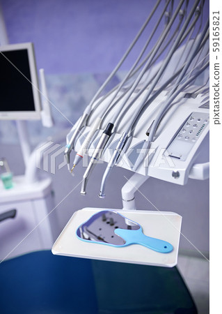 Modern metallic dentist tools and burnishers on a dentist chair 59165821