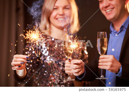 Image of happy couple with champagne glasses and sparklers on black background Image of happy couple with champagne glasses and sparklers on black background 59165975