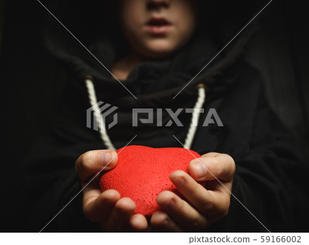 child with a red heart on a dark background 59166002