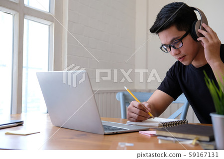 man college student  studying learning lesson with computer online taking note 59167131