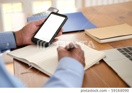 man writing note on notebook. businessman working organizing plan with smart phone at workplace man writing note on notebook. businessman working organizing plan with smart phone at workplace 59168090
