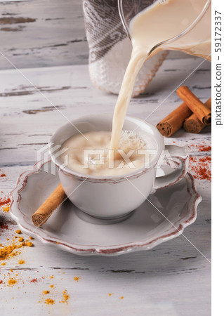 traditional indian masala chai tea pour on a beautiful cup ona shabby wooden texture background, top view. I 59172337