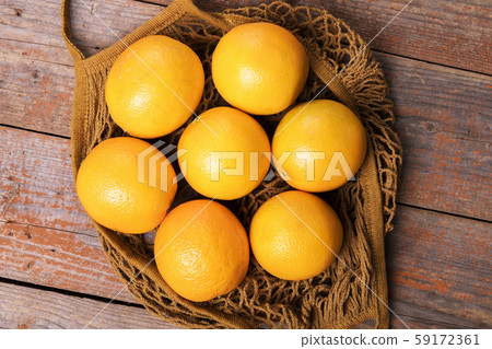 Top view of fresh organic oranges in string bag 59172361