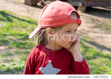 Little girl with star on her clothes and in red cap 59175422