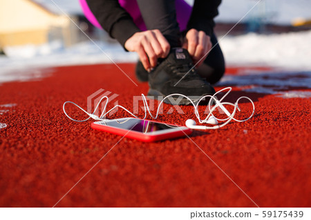 girl athlete in black sneakers, crouching on the girl athlete in black sneakers, crouching on the 59175439